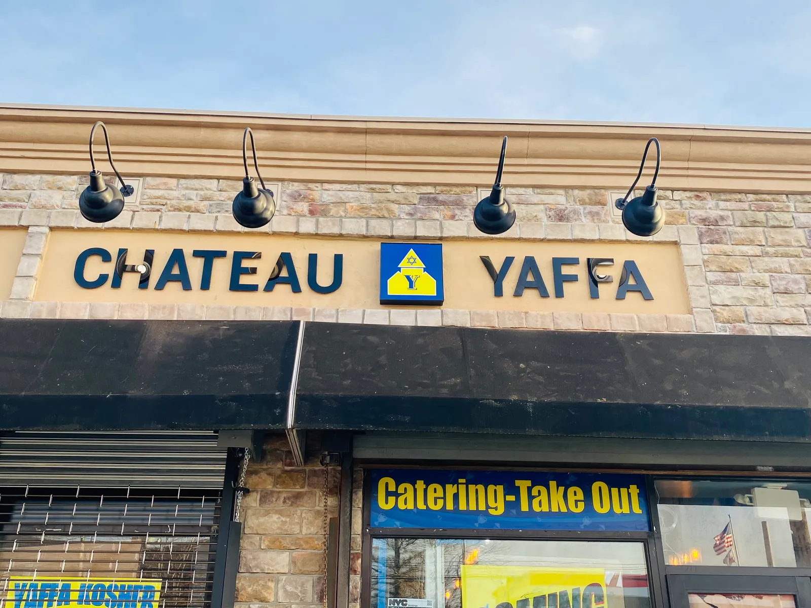 Chateau Yaffa storefront sign with gooseneck lighting in Brooklyn